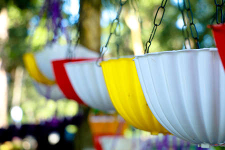 Plastic flower vases in different colors for sale on the roadside, selective focus