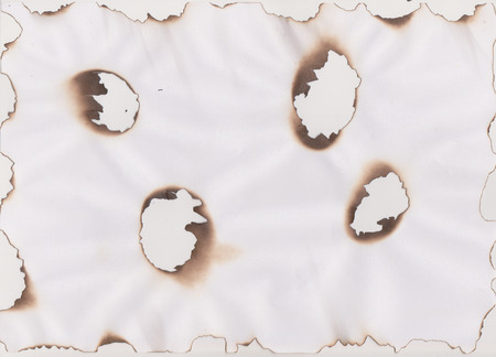 burn effect on paper background with holesの写真素材