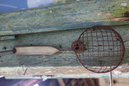 Old and rusty barbecue utensils on a wooden shelf. Selective focus.の写真素材
