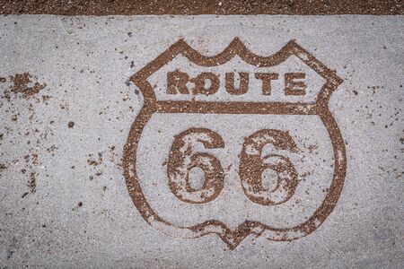 Sand outlines the etched insignia of Route 66 along the main road in the Petrified Forest National...