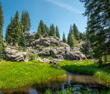 Peaceful scene of a fork of the Jemez River passing by a pretty cluster of boulders at the Valles Caldera, New Mexicoの写真素材