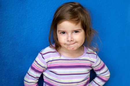 A very cute little girl with Chicken Pox looks at the camera with a mischievous look as if she is...