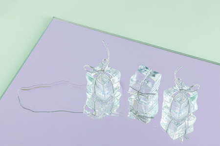 2022. Minimal creative abstract concept of melting gifts with artificial ice cubes isolated on...