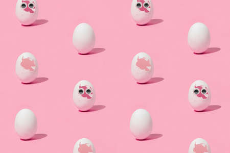 Three white eggs on isolated pastel coral-pink background with shadows. Two with broken shells, one...