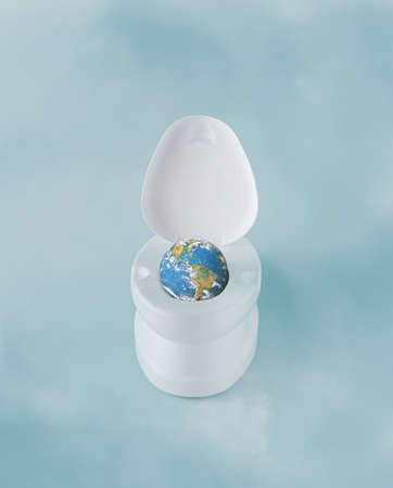 Planet Earth in white toilet on foggy pastel blue background. Minimal art concept of disaster,...