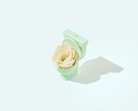 Minimal abstract spring or summer blooming scene with yellow flower and light green toilet, on isolated pastel blue background. Optimistic, cleanliness or good digestion concept.の写真素材