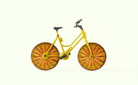 Bicycle with wheels made with round baking trays with baklavas cut into slices. Isolated pastel background. Minimal abstract creative concept of traditional dessert. Food delivery.の写真素材