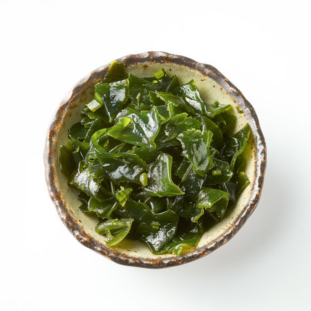 Edible seaweed wakame or kelp salad in a bowl isolated on white background. Top view. Umami flavor algae undaria pinnatifida. Japanese or chinese cuisine. Top view, flat lay.の素材