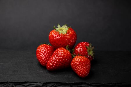 five strawberries against a black backgroundの写真素材