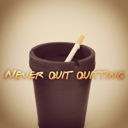 Cigarette in black ashtray isolated on white background with effects and text. Never quit quitting.の写真素材