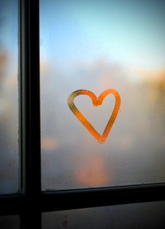 Heart drawn on a foggy window.の写真素材
