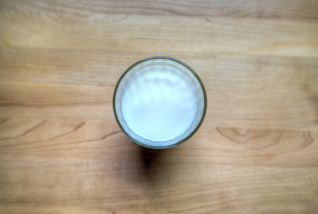 A glass of milk on a wood tableの写真素材
