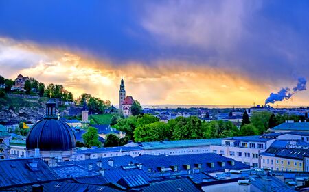 An aerial view of Salzburg, Austria along the Salzach River during a storm.の写真素材