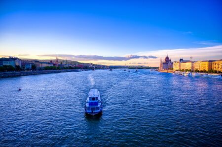 The Hungarian Parliament Building located on the Danube River in Budapest Hungary at sunset.
