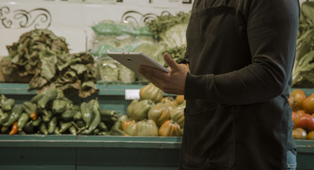 Employee doing inventory in store on tablet with touch screenの写真素材