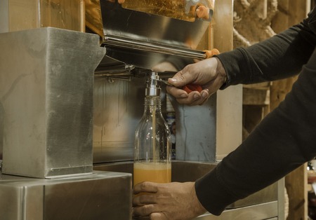 Employee filling a bottle of orange juiceの写真素材
