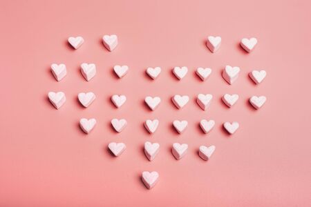 Heart made with heart shaped candy clouds on pink background. Valentine's Day.の写真素材