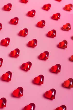 Heart shaped red crystals pattern on pink background. Vertical image Valentine's Day.の写真素材