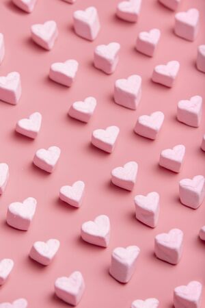 Heart shaped candy cloud pattern on pink background. Vertical image Valentine's Day.の写真素材