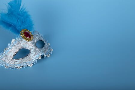Venetian masks of blue color with copy space on blue background. Carnival party concept.