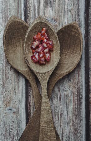 pomegranate pears in wooden spoons on vintage backgroundの写真素材