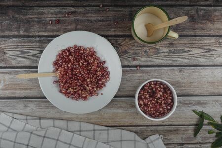 Pomegranate on stone plate with wooden spoon and vintage backgroundの写真素材