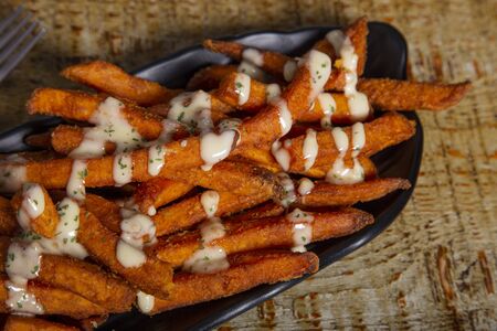 Sweet potato with sauce and parsley. Isolated image