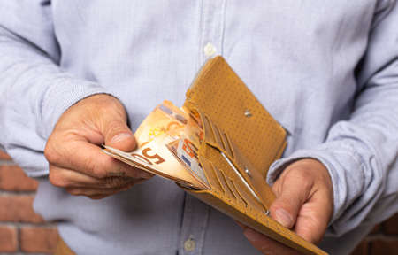 Man taking euro money out of his pocket wallet. isolated image