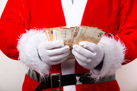 Santa holding fifty Euro bills isolated on white background. European currency