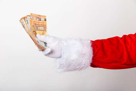 Santa Claus holds money on white backgroundの写真素材