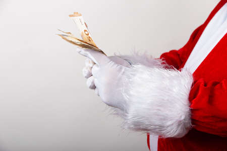 Santa Claus holds money on white background with copy spaceの写真素材