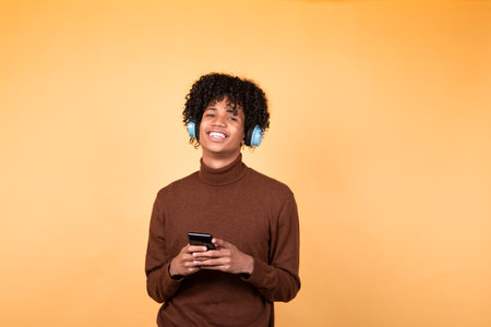 Young man using mobile phone on yellow