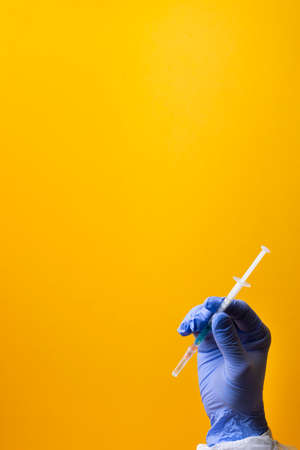 Doctor holding injector with medicines. The surgeon has the vaccine. Syringe with flu vaccine. Medical needle.の写真素材