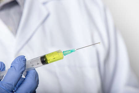 Close up hand of doctor holding  vaccine syringe.Medical treatment concept.の写真素材