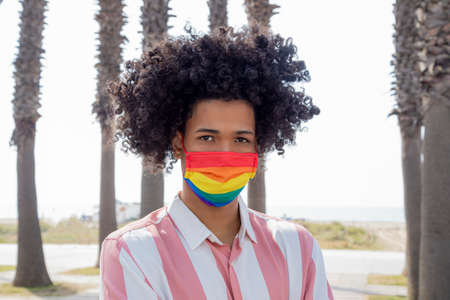 Portrait of a young afro man with gay pride mask