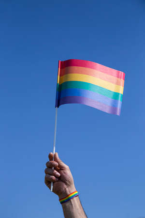 Gay flag with the sky in the background. Vertical imageの写真素材