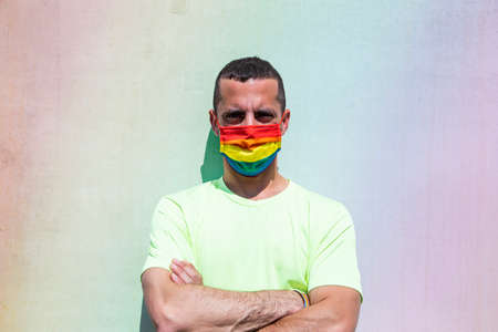 Young man with protective mask and rainbow flag armband. LGTB.の写真素材