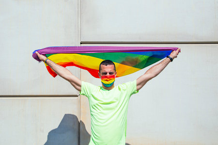 Portrait of man with flag and gay mask