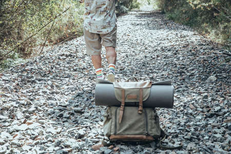 Close up of traveler man and a backpack in the middle of the path of missの写真素材