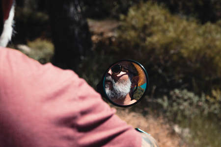 Reflection of Motorcycle Driver in Rearview Mirrorの写真素材