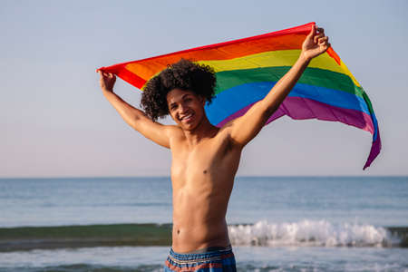 Young latino man with afro hair showing lgtbi flagの写真素材