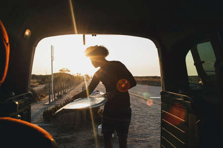 young surfer with hair afro catching a surfboard in caravanの写真素材