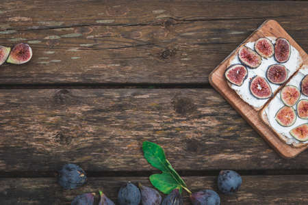 Cream cheese sandwich with figs served on wooden board with copy spaceの写真素材