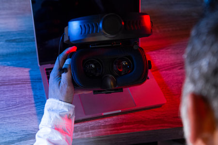 Top view of man's hand picking up a virtual reality glasses