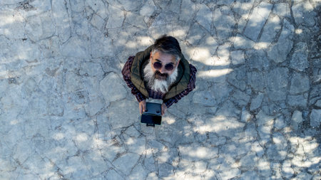 A man is controlling his drone and taking some photos and videos. Aerial top view, technology and lifestyle concept.の写真素材