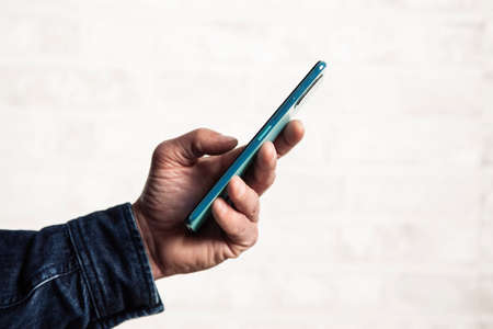 close up of a man's hand using a smart mobile phoneの写真素材