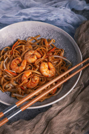 Close up of a bowl of Chinese noodles with shrimp and chopsticks. Chinese cuisine.の写真素材