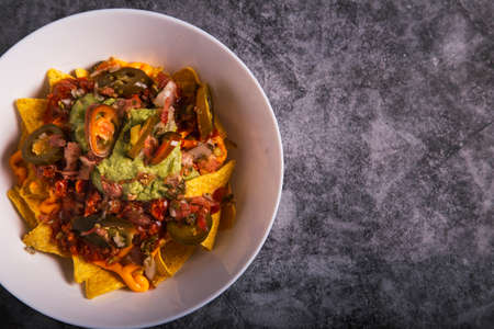 Mexican nachos with pico de gallo and guacamole. Dark background. Copyspace. Top view.の写真素材