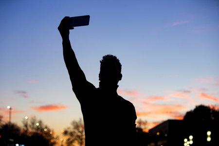 Silhouette of man taking a selfie with the golden sun. peaceful view