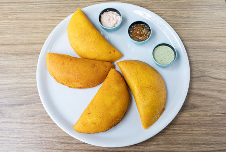 Typical food of Colombian gastronomy. Fruit empanadas stuffed with chicken with three types of sauceの写真素材